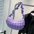 Quilted lavender puffer crescent bag with ruched shoulder strap hanging on hanger - Purple