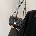 Elegante schwarze gesteppte Umhängetasche mit Silberkette und rundem Drehverschluss - Schwarz