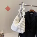 White ruched cloud shoulder bag featuring textured bubble fabric and ruffled strap - White