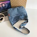 Umhängetasche aus verwaschenem blauem Denim mit verstellbarem Riemen und Etikett - Vintage-Blau