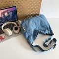 Blaue Denim-Umhängetasche mit verstellbarem Gurt und orangefarbenem Etikett für den Alltag - Hellblau