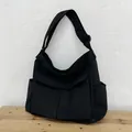 Minimalistische schwarze Canvas Umhängetasche mit Seitentaschen und breitem Gurt - Schwarz