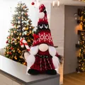 Detalle de gnomo navideño de peluche con bastón de caramelo y fondo festivo cálido - Gnomo Femenino con Bastón de Caramelo