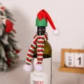 Close-up of mini knitted Christmas hat and scarf set on a wine bottle for festive decor - Red Hat And Scarf