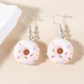 Detail of pink resin donut earrings with white cream frosting and colorful sprinkles - Donut / White