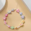 Dettaglio del ciondolo per telefono Y2K con farfalle e fiori in colori pastello - Cordino in Resina Farfalla Fiore Colorata
