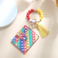 Dettaglio del porta carte natalizio con perline di silicone e ciondolo nappa giallo - Strisce arcobaleno