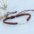 Dettaglio del bracciale intrecciato marrone regolabile con pendente a croce argento - Marrone