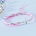 Dettaglio del bracciale a cordoncino rosa intrecciato a mano con croce d'argento lucido - Rosa