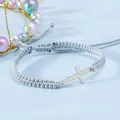Dettaglio macro del bracciale in corda grigia intrecciata a mano con croce metallica - Blu grigiastro