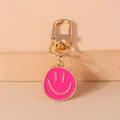 Detail of rose pink smiley face metal keychain with a polished gold D-ring swivel clasp - Rose Red