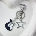 Punk vintage metal guitar keychain with silver star and heart clasp on white tray - Hollow Star Black Guitar Keychain