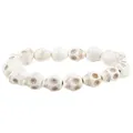 Macro shot of white howlite skull beads with detailed engravings on the stretch bracelet - White
