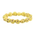 Close-up of yellow skull beads with dark web texture on a creative Halloween bracelet - Yellow