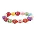 Macro shot of colorful skull-shaped beads showing natural stone texture and fine carvings - Colorful