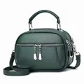 Dark green pebble leather handbag with triple zippers and silver hardware in a 45-degree view - Dark Green