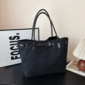 Bolso tote minimalista de lona negra para mujer con detalle de hebilla de cinturón de cuero - Negro