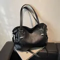 Large black vintage tote bag with silver metal buckles and dual handles on a leather bench - Dark Gray