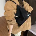 Bolso tote negro de ante sintético y charol con diseño minimalista usado por modelo - Negro