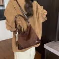 Bolso tote de ante marrón con detalles de cuero brillante y un amuleto de cuentas - Café