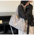 Detailed side view of large grey matte tote bag worn by a model in minimalist setting - Gray