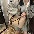 Beige faux leather tote bag with dark brown straps and decorative woven charm - Khaki