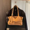 Vintage Tragetasche aus mattem braunem Leder mit dekorativer Schnalle an schwarzem Sakko - Braun