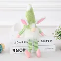 Easter gnome plush doll with pink bunny ears and long legs on white books - Green Lighted Figurine Pendant (L-FH53) / Green