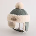 Detail van de kinderwintermuts van groen suède, imitatiebont en een schattige berenpatch - Peuters 1-3 Jaar / Bleekgroen