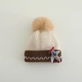 Detail van gebreide baby muts met schattig vliegtuigje en grote zachte pompon - Kinderen 2-8 Jaar / Beige