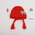 Detail of red knit kids hat with cute bear patch and thick braided tassels on sides - Baby One Size Elastic / Bear Red