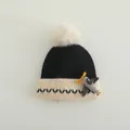 Detail van de gebreide textuur van de kinderwintermuts met pompon en vliegtuig - Kinderen 2-8 Jaar / Zwart