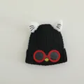 Detail view of children's black knit hat featuring plush cat ears and cartoon eye glasses - Cat Style (TYJM04) / Black