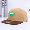 Detalle de la gorra plana de lona caqui con un parche triangular verde decorativo - Estilo 2 Etiqueta Verde Caqui