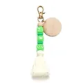 Detailed view of silicone beads with HBD letters and white cotton tassel on keychain - Green