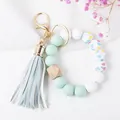 Detail of beaded keychain wristlet with mint silicone beads, wood hex bead, and leather tassel - Light Green Heart Print