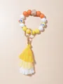 Detail van de sleutelhangerarmband met houten kralen en gele kleurverloop kwastjes - Geeloranje Stijl