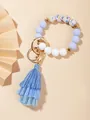 Dettaglio del bracciale con perle in silicone blu fiorito, chiusura dorata e nappa in tessuto - Peonia Blu (PZ2307159640)