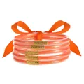Detalle de pulseras de silicona naranja con purpurina y conectores de metal dorado - Naranja