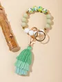 Dettaglio delle perle in silicone con uccelli e nappa verde sul portachiavi ad anello - Verde Foresta Tropicale (PZ2307159640)