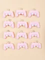 Flat lay of 12 pink resin game controller charms for DIY crafts and jewelry making - Pink Game Controller