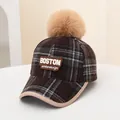 Detail of a kids plaid baseball cap featuring a large pompom and BOSTON embroidery - Kids (48-54CM) / BOSTON Grey Coffee Plaid
