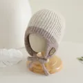 Gedetailleerde gebreide textuur van een warme babymuts met een schattige smiley - Beige