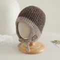 Dettaglio della trama a maglia e patch sorriso su questo caldo cappello invernale per neonati - Caffè