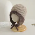 Dettaglio del cappello in maglia per neonati con fibre bicolore e toppa sorridente - Grigio chiaro