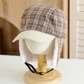 Detailed view of winter plaid trapper hat with warm white fleece lining and adjustable strap - Kids / Off White