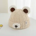 Detail der beigen Winterstrickmütze für Kinder mit Bärenohren und Plüschtiergesicht - 2-7 Jahre / Beige