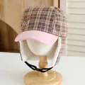 Detail view of winter plaid hat with orange-black pattern and soft white faux fur lining - Kids / Pink