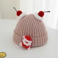 Close-up of pink knitted winter hat with Santa patch and red-white pom-poms for kids - One Size / Dusty Pink