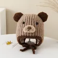 Détails de la texture tricotée d'un bonnet d'ours brun avec oreilles 3D et cache-oreilles bébé - Style Élastique pour Enfants / Kaki